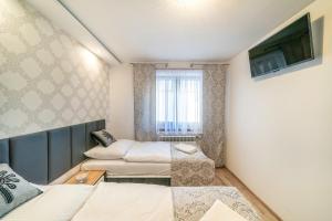 a room with two beds and a tv at Apartament Glamour in Biały Dunajec