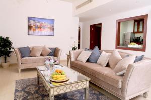 a living room with a couch and a table with fruit on it at Luxury Casa - Grand Sea View Apartment JBR Beach 2BR in Dubai