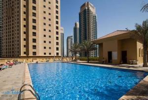 a large swimming pool in a city with tall buildings at Luxury Casa - Grand Sea View Apartment JBR Beach 2BR in Dubai