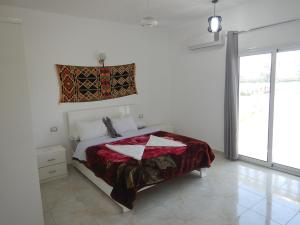 um quarto com uma cama com um cobertor vermelho em Luxor VIP Apartments em Luxor