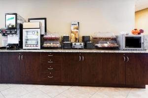 um balcão de cozinha com micro-ondas e electrodomésticos em Microtel Inn & Suites by Wyndham Macon em Macon