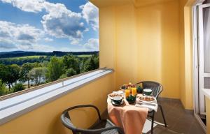 una mesa y sillas con vistas a una ventana en Exclusive HOTEL Lipno Wellness & SPA, en Frymburk