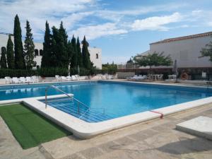 a large swimming pool with chairs and trees at Avenida Manila, 4 Apartamento in Alcossebre