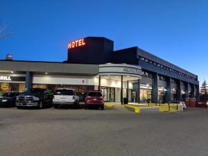 un hôtel avec des voitures garées dans un parking dans l'établissement Argyll Plaza Hotel, à Edmonton