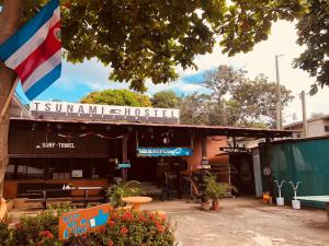 a building with a flag in front of it at Tsunami Hostel in Tamarindo