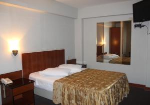 Habitación de hotel con cama y espejo en Hostal Bond, en Lima