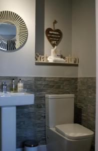 uma casa de banho com um WC, um lavatório e um espelho. em No27 Ayr Beach - Coorie Doon Stays em Ayr