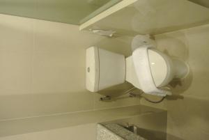 La salle de bains est pourvue d'un urinoir blanc sur le mur. dans l'établissement S Tara Grand, à Surat Thani