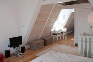 a living room with a tv and a table at Kalkmarkt Suites in Amsterdam