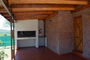 ein Wohnzimmer mit einer Ziegelwand und einem Kamin in der Unterkunft Solares de Tanti in Tanti Nuevo
