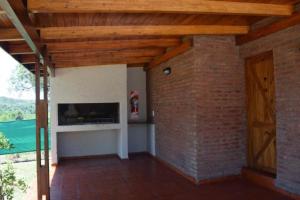 sala de estar con pared de ladrillo y chimenea en Solares de Tanti en 