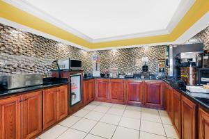 a large kitchen with wooden cabinets and appliances at Super 8 by Wyndham Byron/South Macon in Byron