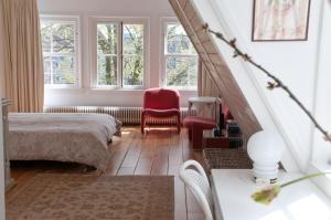 Schlafzimmer mit einem Bett, einem Stuhl und Fenstern in der Unterkunft Kalkmarkt Suites in Amsterdam