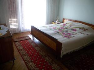 a bedroom with a large bed and a red rug at Apartment Fazana, Istria 13 in Fažana