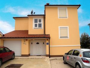 a house with two cars parked in front of it at Apartment Liznjan 4 in Ližnjan