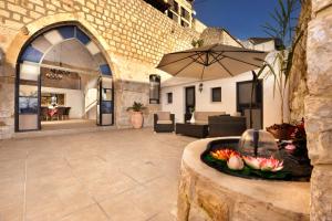 a patio with an umbrella and flowers in a fountain at The Antiquity Heart Mansion in Safed