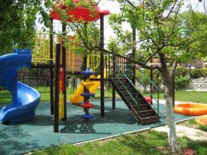a playground with a slide in a park at Hotel Villa Ofir in Sandanski
