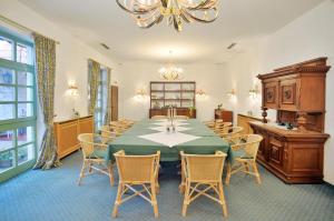 a dining room with a table and chairs and a chandelier at Stadthotel Patrizier in Schmalkalden