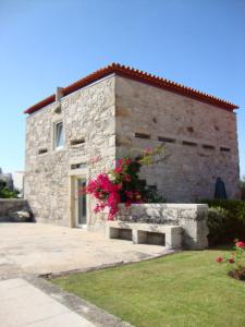 ein Steingebäude mit einer Bank davor in der Unterkunft Alltominho – Villas Summer Holidays in Afife