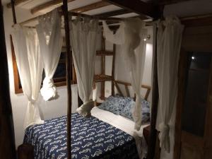 a bedroom with a canopy bed with white curtains at Mancora Apartments in Máncora +100 photos