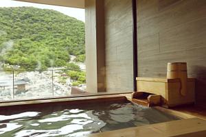 a bath tub with a view of a mountain at Unzen Kyushu Hotel in Unzen