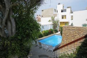 a swimming pool in a yard next to a building at Huanchaco Hostal in Huanchaco