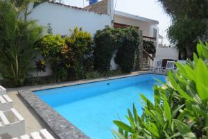 a swimming pool in front of a house with plants at Huanchaco Hostal in Huanchaco