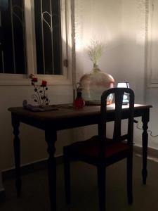 een tafel met een stoel en een vaas erop bij Ti case en l'air in Cilaos