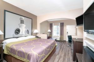 a hotel room with a bed and a flat screen tv at Super 8 by Wyndham Murfreesboro in Murfreesboro