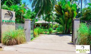 a gate to a resort with palm trees and a building at Pavana Hotel Negombo in Negombo