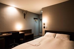 益田的住宿－Hotel Daiei Masuda，酒店客房配有一张床、一张书桌和一张书桌。