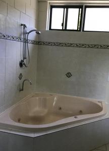 a large bath tub in a bathroom with a window at Harbour Lodge Motel in Gladstone +14 photos