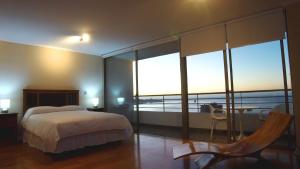 1 dormitorio con cama y vistas al océano en Alluring View at Valparaiso departamento, en Valparaíso