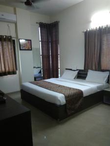 ein Schlafzimmer mit einem großen Bett in einem Zimmer in der Unterkunft Balaji Lodging in Pandharpur