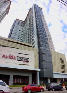 a tall building with cars parked in front of it at Avida Towers Davao in Davao City