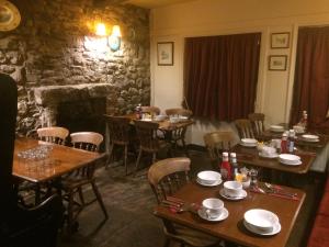 a dining room with tables and chairs and a fireplace at Fox and hounds starbotton in Starbotton