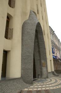 a tall building with an arch in front of it at Optima Collection Dnipro in Dnipro