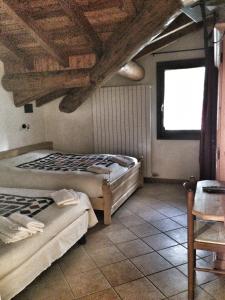 1 dormitorio con 2 camas, mesa y ventana en albergo panoramico, en Lenna