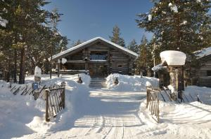 a log cabin in the snow with a gate at Villa Rukapiste in Ruka