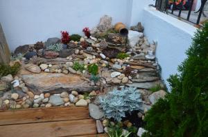 a garden with rocks and plants on a balcony at Os Piratas in Charneca