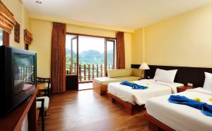Habitación de hotel con 2 camas y TV de pantalla plana. en Phi Phi Arboreal Resort, en Islas Phi Phi