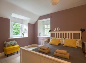 um quarto com uma cama grande e almofadas amarelas em Lovely house next to Euchan River em Sanquhar
