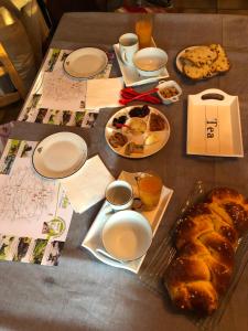 a table with plates of food and bread on it at Les chambres de cathy in Labastide-Murat