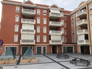 an apartment building with benches in front of it at Via Acquedotto n. 66, Condominio "Le Piramidi" in Olbia