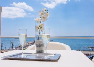 two glasses of wine on a table next to the ocean at Hotel Fontana in Amalfi