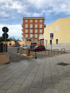 a parking lot with a building and cars in a city at Via Acquedotto n. 66, Condominio "Le Piramidi" in Olbia +2 photos