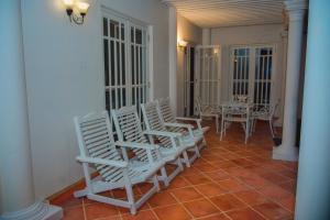 un grupo de sillas blancas y una mesa en una habitación en Donald Mansion, en Negombo