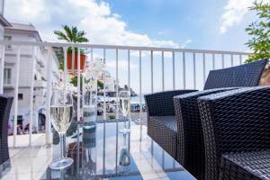 a balcony with a glass table with wine glasses at Hotel Fontana in Amalfi