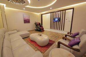Golden Night Hotel في نجران: غرفة معيشة بأثاث أبيض وتلفزيون