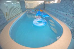 a swimming pool with a blue tub in a water park at Golden Night Hotel in Najran